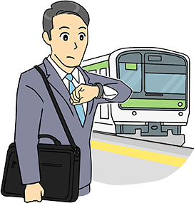 ホームで時計を見るスーツの男性